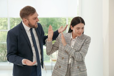 Photo of Man screaming at woman in office. Toxic work environment