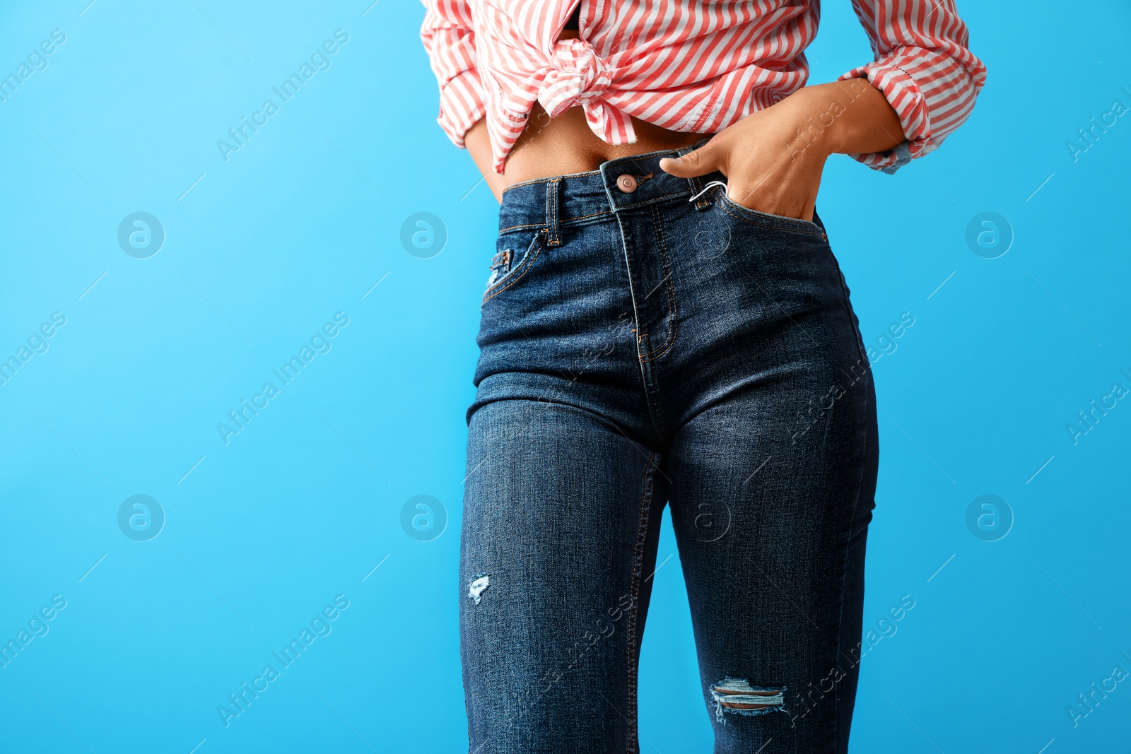 Photo of Woman wearing jeans on blue background, closeup