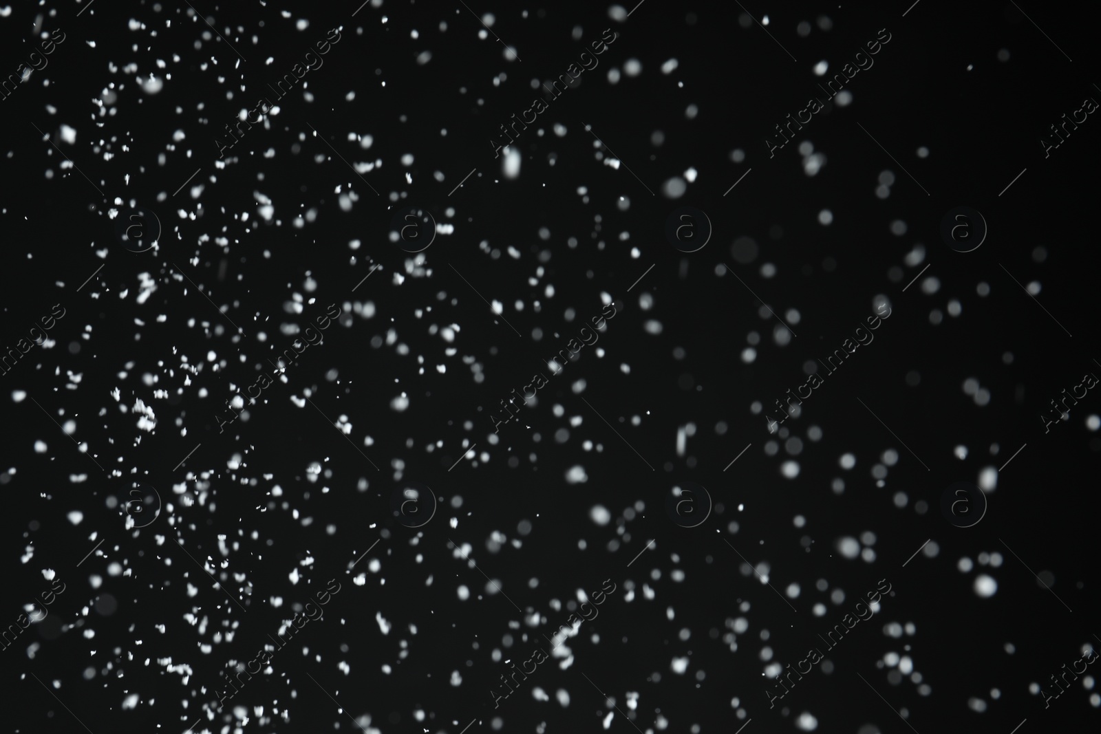 Photo of White snow falling down on black background