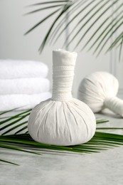 Photo of Spa bags and palm branches on light gray marble table