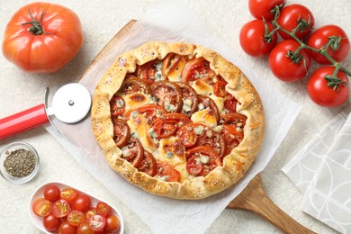 Flat lay composition of tasty galette with tomato and cheese (Caprese galette) on light textured table