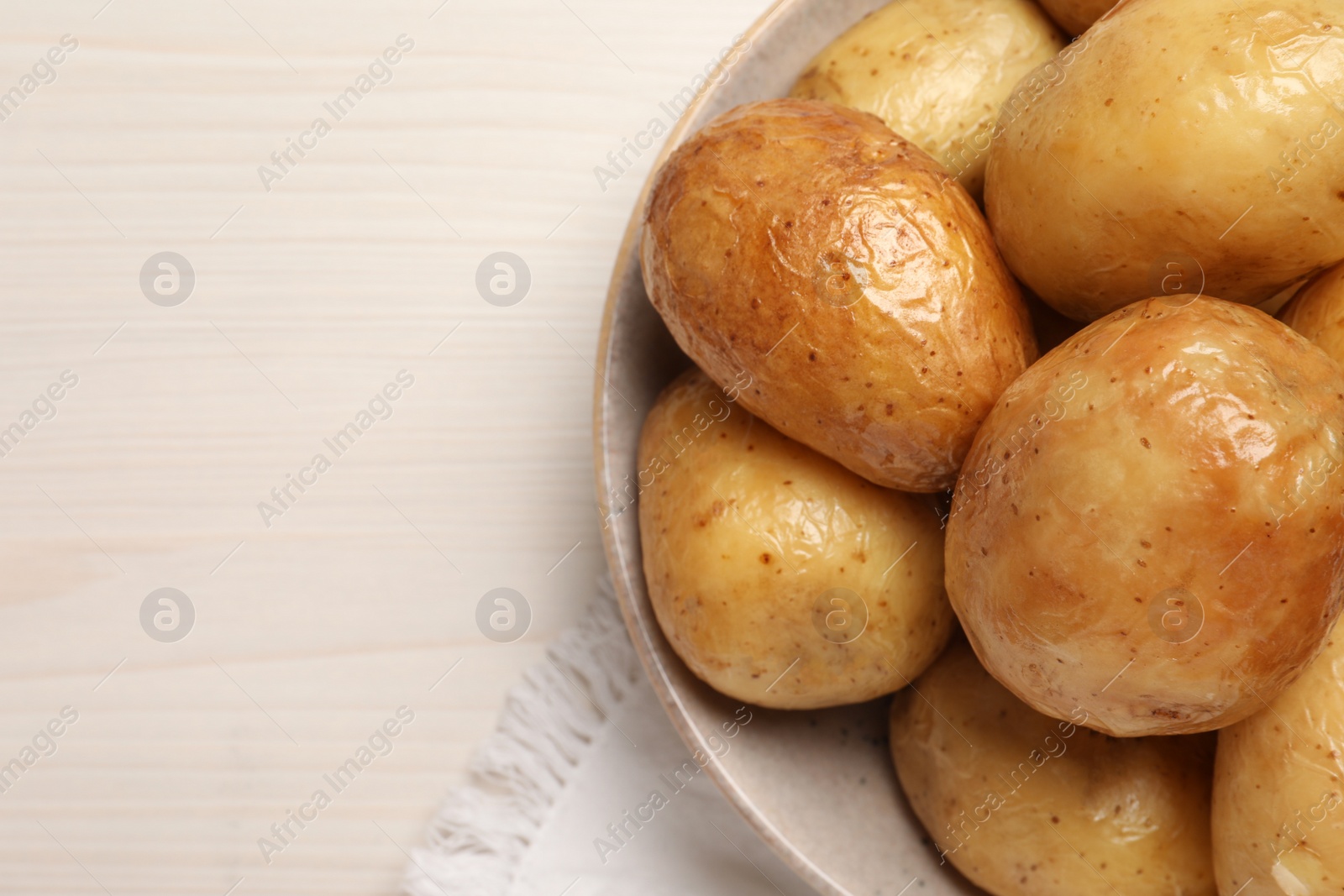 Photo of Delicious baked potatoes on white wooden table, top view. Space for text