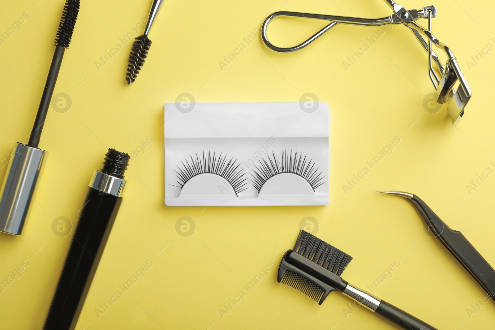 Photo of Flat lay composition of professional makeup tools and false eyelashes on color background