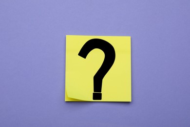 Photo of Sticky note with question mark on violet background, top view