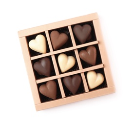 Photo of Delicious heart shaped chocolate candies in box isolated on white, top view