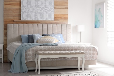 Photo of Comfortable bed with soft color pillows indoors
