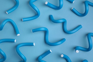 Photo of Curling rods on light blue background, flat lay. Hair styling tool