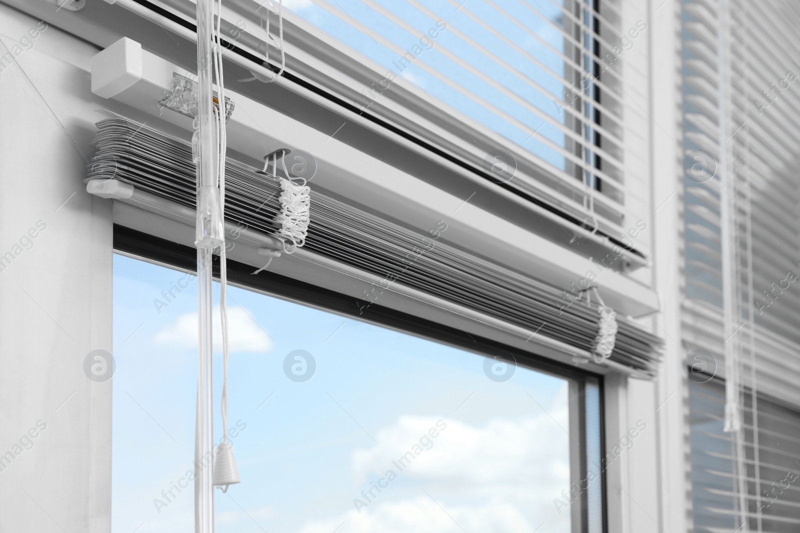 Photo of Window with horizontal blinds and control system indoors, closeup