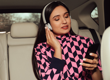 Photo of Young woman listening to audiobook in car