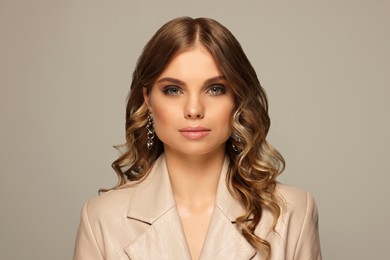 Photo of Portrait of young woman with beautiful makeup on grey background