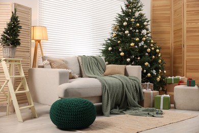 Photo of Christmas tree in room decorated for holiday. Festive interior design