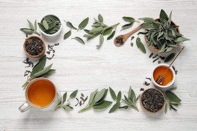 Photo of Flat lay composition with cup of sage tea and green leaves on white wooden table. Space for text