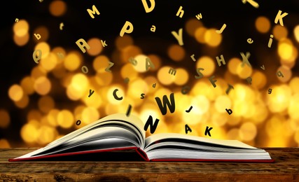 Image of Letters flying out from open book on wooden table, bokeh effect. Banner design