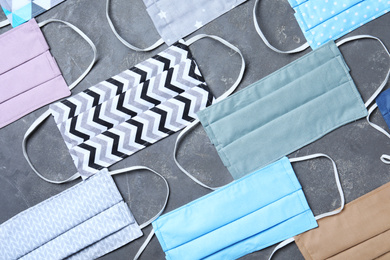 Photo of Flat lay composition with homemade protective masks on grey stone background. Sewing idea