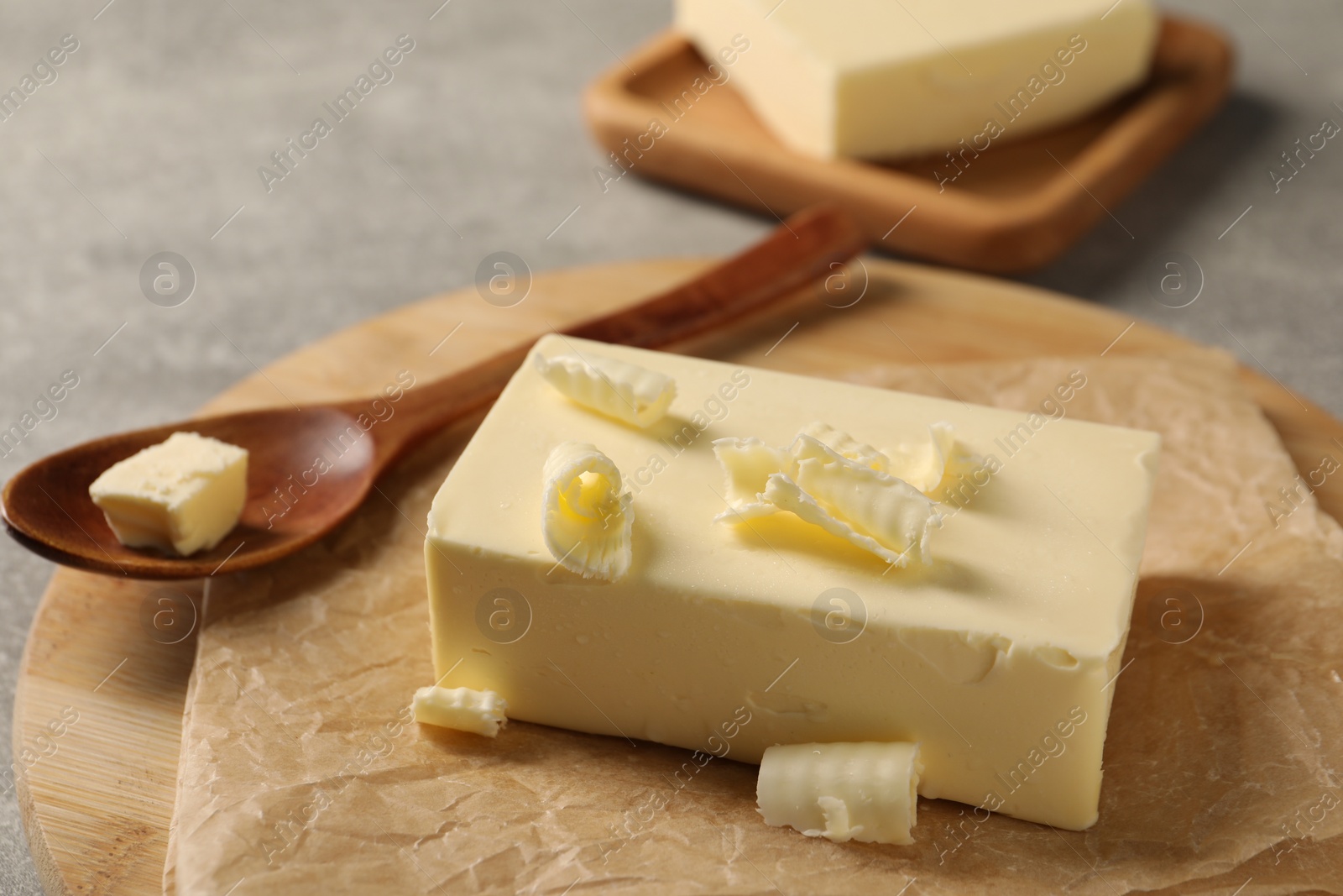 Photo of Block of tasty butter on grey table, closeup