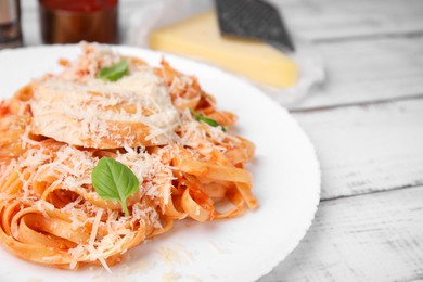 Photo of Delicious pasta with tomato sauce, chicken and parmesan cheese on white wooden table, closeup. Space for text
