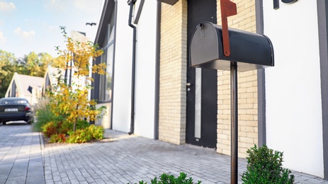 Photo of Black mailbox near house outdoors on sunny day