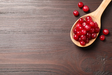 Photo of Fresh cranberry on wooden table, flat lay. Space for text