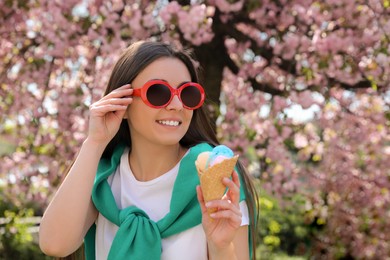 Photo of Young woman with icecream in beautiful park