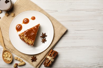 Photo of Tasty cheesecake with caramel and nuts served on white wooden table, flat lay. Space for text