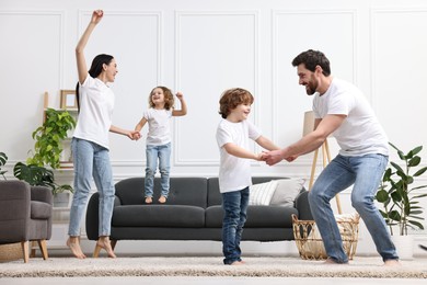 Photo of Happy family dancing and having fun in living room