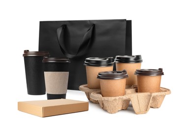 Set with different takeaway cups and paper bag on white background