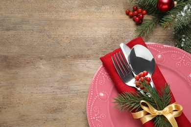Photo of Christmas table setting on wooden background, flat lay. Space for text