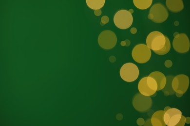 Photo of Blurred view of festive lights on green background, space for text. Bokeh effect