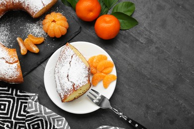 Photo of Piece of delicious homemade yogurt cake with powdered sugar and tangerines on gray table, flat lay. Space for text
