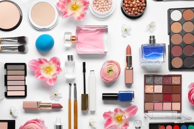 Photo of Flat lay composition with different makeup products and beautiful spring flowers on white background
