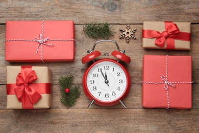 Photo of Flat lay composition with Christmas gifts and alarm clock on wooden table. Boxing day