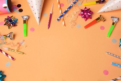 Photo of Party blowers, streamers and other festive decor on coral background, above view. Space for text