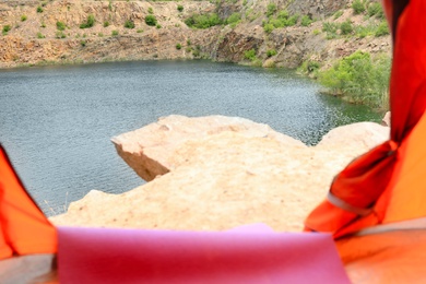 Photo of Calm river with rocky banks, view from camping tent