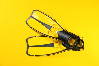 Photo of Swimming flippers on color background, top view