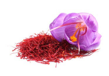 Photo of Pile of dried saffron and crocus flower on white background