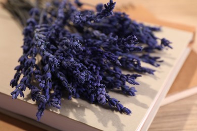 Photo of Bouquet of beautiful preserved lavender flowers and notebooks on table, closeup