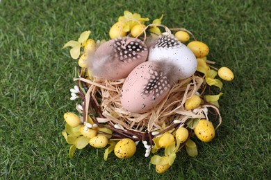 Photo of Festively decorated Easter eggs on green grass, closeup