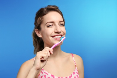Photo of Portrait of young woman with toothbrush on color background. Space for text