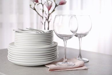 Photo of Set of clean dishes on table against blurred background