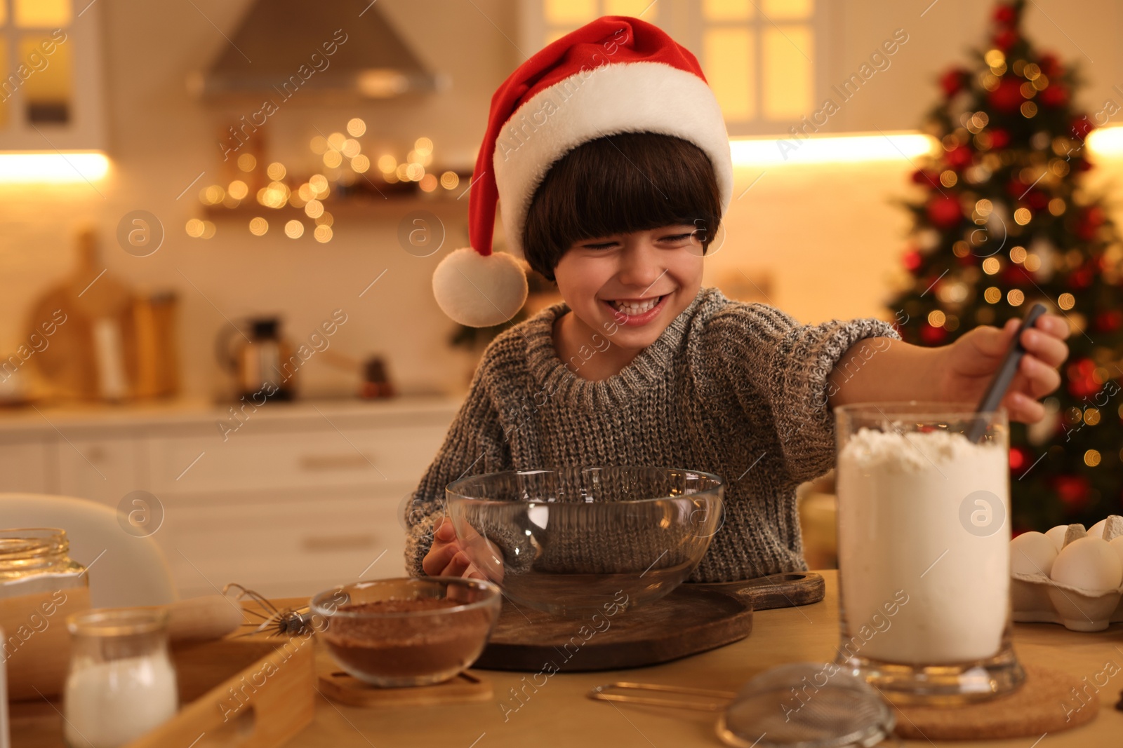 Photo of Cute little boy making Christmas cookies in kitchen