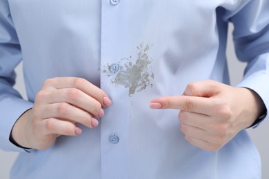 Photo of Woman showing stain on her shirt, closeup