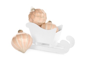 Photo of Wooden sleigh with Christmas balls on white background