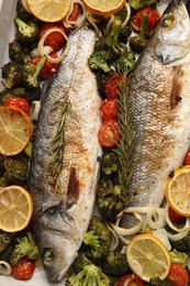 Photo of Delicious fish with vegetables and lemon in baking dish, flat lay
