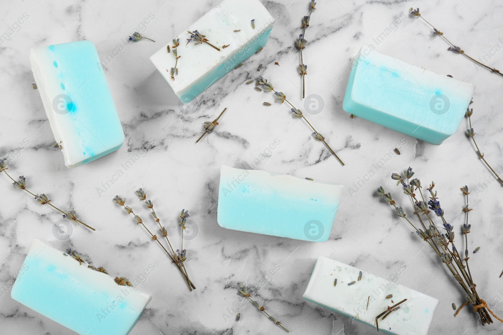 Photo of Flat lay composition with natural handmade soap and dry lavender on white marble table