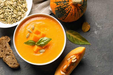 Photo of Flat lay composition with bowl of pumpkin soup on table