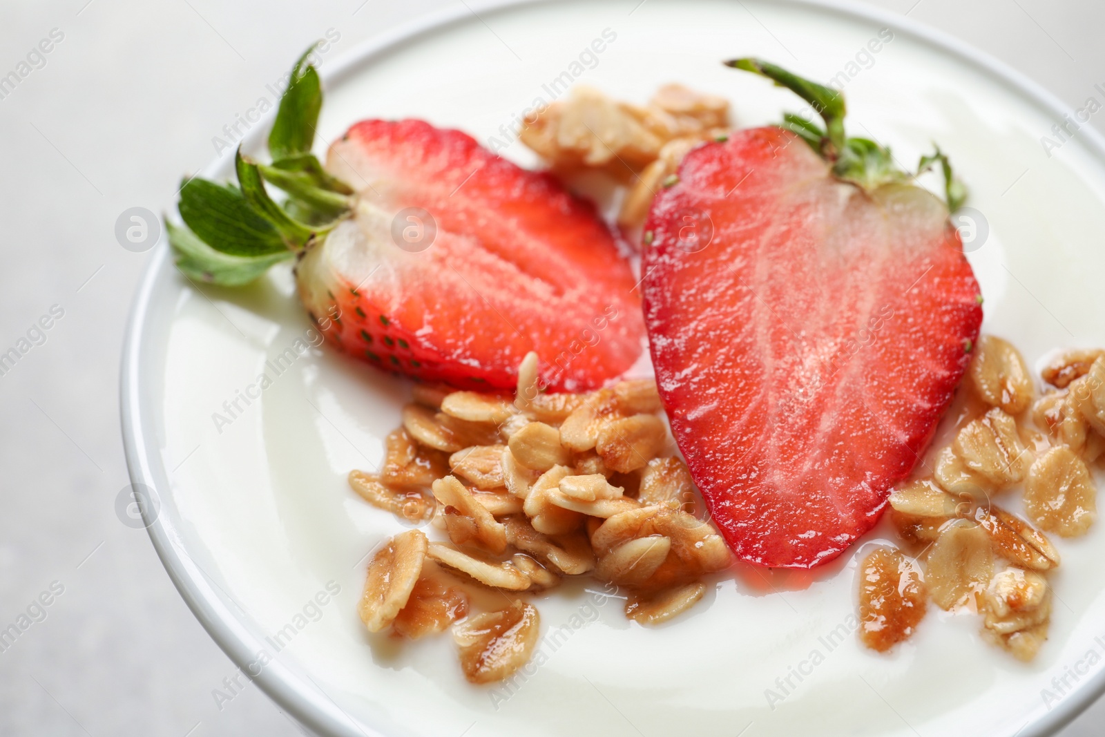 Photo of Bowl with tasty yogurt, strawberry and granola, closeup