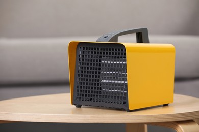 Photo of Modern electric fan heater on coffee table in room. Space for text