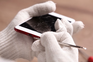 Photo of Technician fixing mobile phone at table, closeup. Device repair service