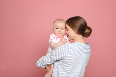 Photo of Happy mother with her baby on color background. Space for text