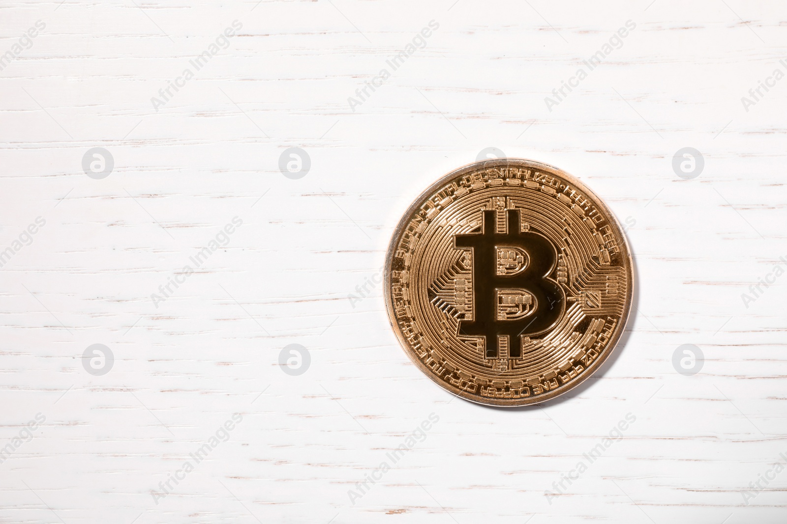 Photo of Golden bitcoin on wooden table, top view. Space for text